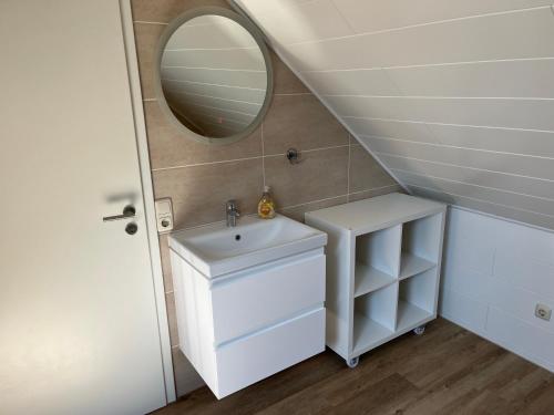 a bathroom with a sink and a mirror at Apartment Topp adult only in Wangerland