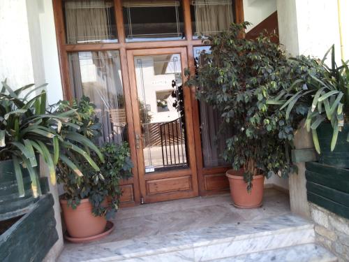 a front door of a building with potted plants at Akrogiali in Kyparissia