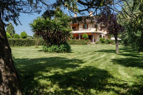 a house in the middle of a yard with trees at Casa Vittoria in Potenza Picena