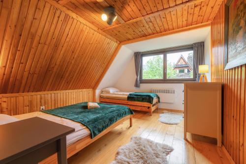 een slaapkamer met 2 bedden in een houten hut bij Willa Lavinka in Zawoja