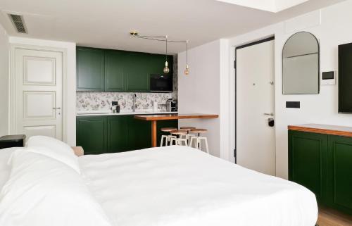 una camera da letto con armadi verdi e un letto bianco di Il Caruggio Flat a Varazze