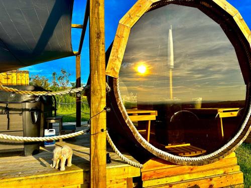 a cat sitting on a wooden dock with a rope at Deerstone Glamping-Pinhaw Beacon dome Hot tub in Earby