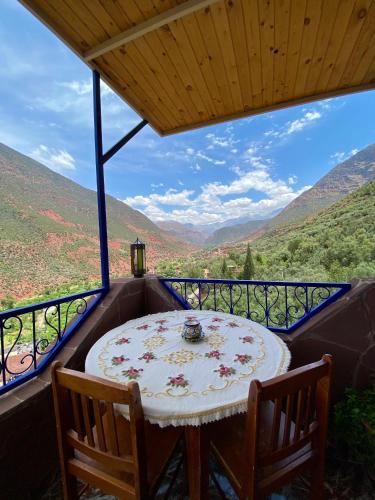 a table on a balcony with a view of mountains at DAR EL HACHIMI EL IDRISSI in Ourika