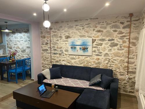 een woonkamer met een bank en een stenen muur bij Filipa Apartment in Limenas
