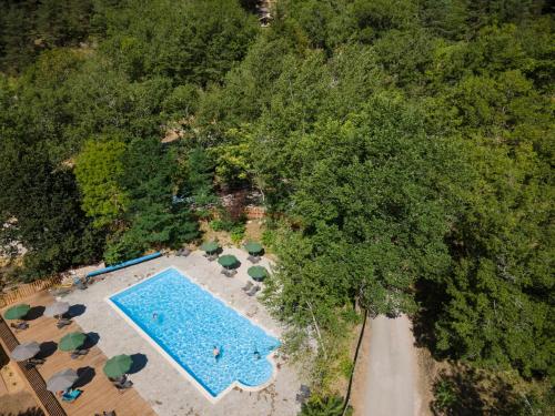 an overhead view of a swimming pool with trees at Huttopia Gorges du Tarn in Les Vignes