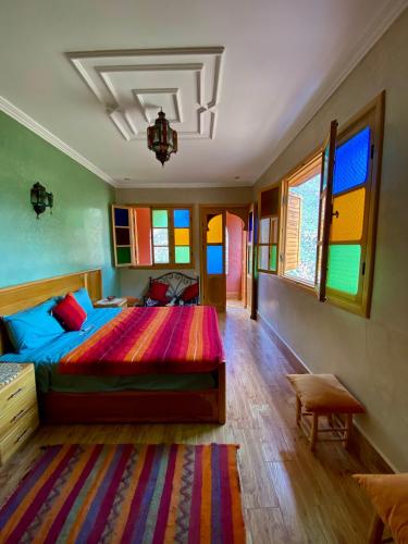 a bedroom with a large bed with a colorful spread at DAR EL HACHIMI EL IDRISSI in Ourika