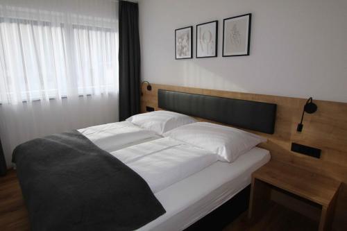 a bedroom with a bed with white sheets and a wooden headboard at Apart Christoph in Oetz