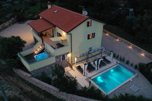 an aerial view of a house with a swimming pool at Holiday house Toš-Vila with heated pool in Vrbnik