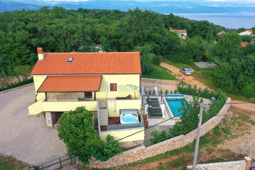 an aerial view of a house with a swimming pool at Holiday house Toš-Vila with heated pool in Vrbnik