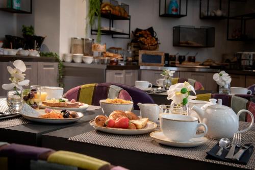 a table with plates of food and cups of coffee at Best Western Plus Nice Cosy Hotel in Nice