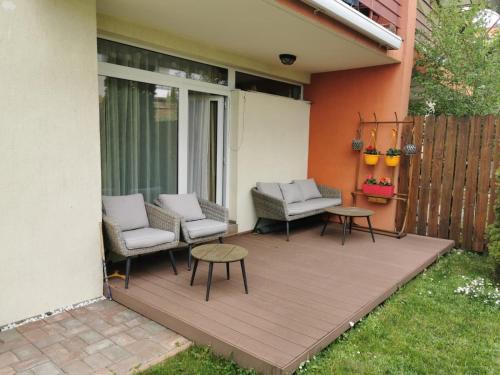 een patio met 2 stoelen en 2 tafels op een huis bij Harmony Haven in Cluj-Napoca