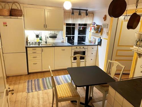 een kleine keuken met een tafel en een tafel en stoelen bij Cozy holiday home in Tranas, Odeshog in Tranås