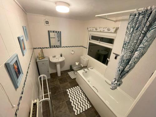 Baño pequeño con bañera y lavamanos en 2 Bed 1st Floor Flat near Centre en Nottingham