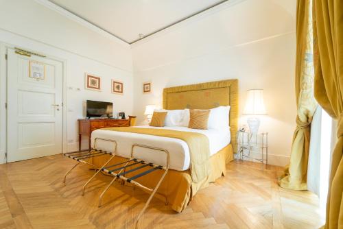 ein Schlafzimmer mit einem großen Bett und einem TV in der Unterkunft Relais Villa San Martino in Martina Franca