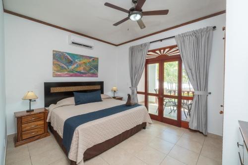 a bedroom with a bed and a ceiling fan at Delluz Bahia Azul 4B Pool view, Jaco Beach 2nd floor in Jacó