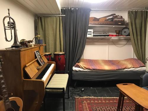 a room with a piano and a bed at Bolinderbyn in Järfälla