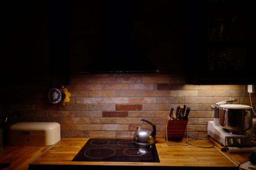 a kitchen counter with a stove top oven next to a brick wall at Bolinderbyn in Järfälla