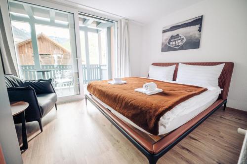 a bedroom with a bed and a chair and a window at House on Lake/ HL in Därligen