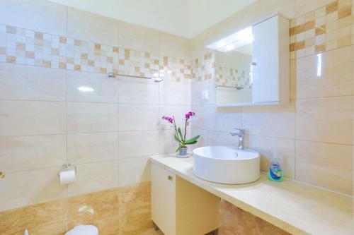 a white bathroom with a sink and a mirror at Fran Apartments in St. Spyridon Corfu
