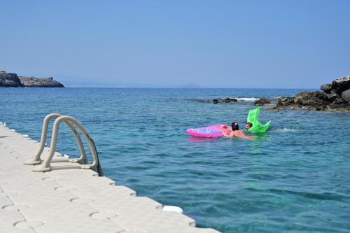 a couple of people in the water on an inflatable at Kavos Hotel & Suites in Stavros