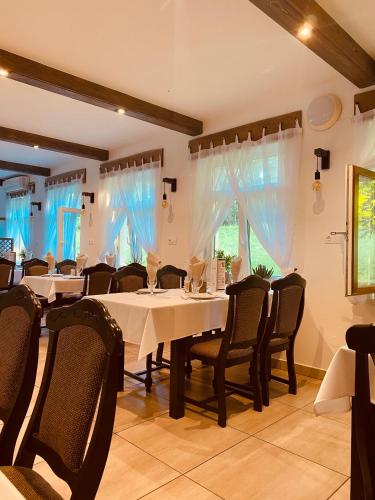a dining room with white tables and chairs at Tanyacsárda Panzió in Baja