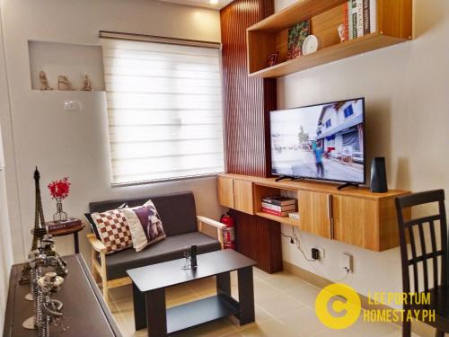- un salon avec un canapé et une télévision dans l'établissement F524 Place at SMDC Cheer Residences by Lee Portum, à Marilao