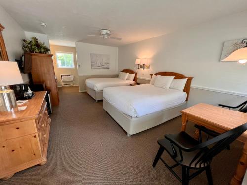 a hotel room with two beds and a desk at Main Street Motel in Fish Creek