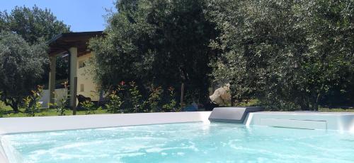 bañera de hidromasaje con silla en el patio trasero en Carmen de Nella Eco Lodge 4*, en Caprino Veronese