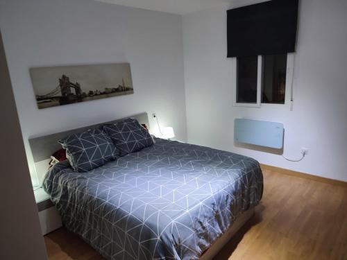 a bedroom with a bed with a blue comforter at Bedroom to rent in the beach in Valencia