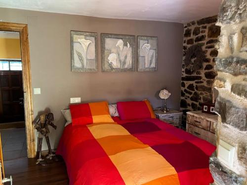 a bedroom with a bed with a colorful blanket at Casa Lici in Robles de Laciana