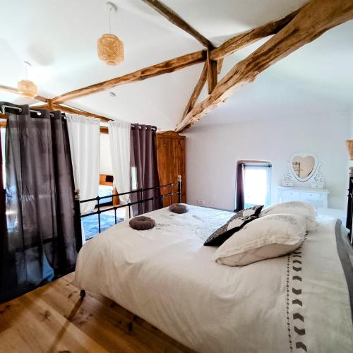 1 dormitorio con 1 cama grande en una habitación con suelo de madera en Baladous, en Montgaillard-de-Salies