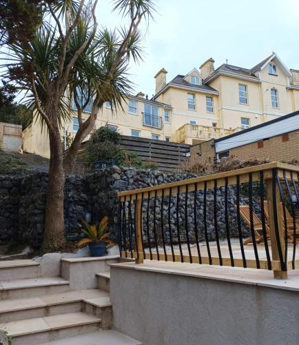 a staircase in front of a building with palm trees at Strawberry Fields - CENTRAL TORQUAY in Torquay
