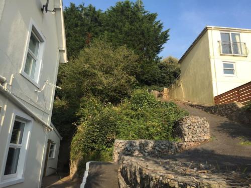 a house and a stone wall next to a building at Strawberry Fields - CENTRAL TORQUAY in Torquay