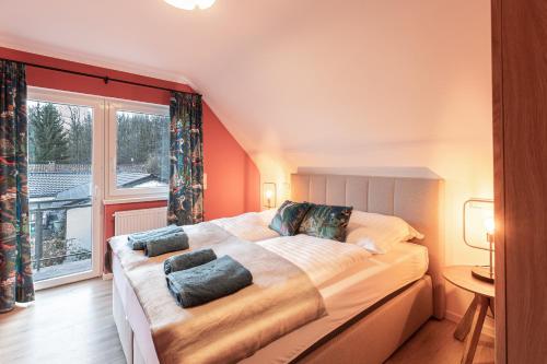 a bedroom with a large bed and a large window at Haus Cervus in Hattgenstein