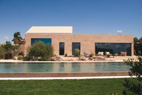 a house with a swimming pool in front of a house at Rakalia Pure Living Sicilian Retreat in Marsala