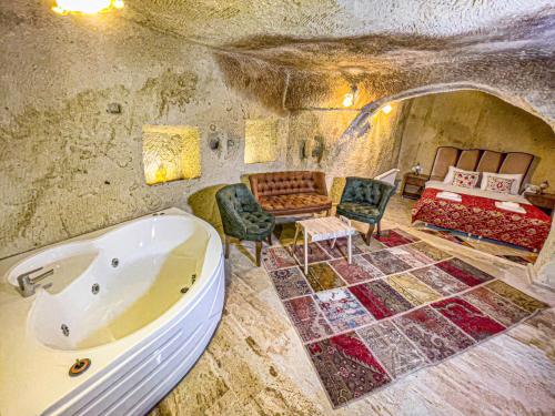 a large bathroom with a tub and a bedroom at Heritage Cave Suites in Ürgüp