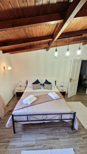 ein Schlafzimmer mit einem großen Bett in einem Zimmer mit Holzdecken in der Unterkunft La Corte Liberty Rosa in Iglesias