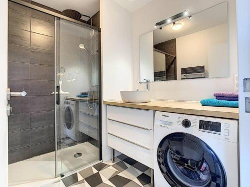 La salle de bains est pourvue d'un lave-linge et d'une douche. dans l'établissement Appartement entre ciel et mer le grand large, à Hyères