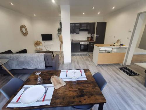 a living room with a table and a kitchen at Le Vosgien - Hyper center - Calm in Épinal