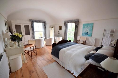 een slaapkamer met een groot bed en een tafel en stoelen bij Bantham House, Bantham, South Devon - a few steps from golden sandy beaches in Bigbury on Sea