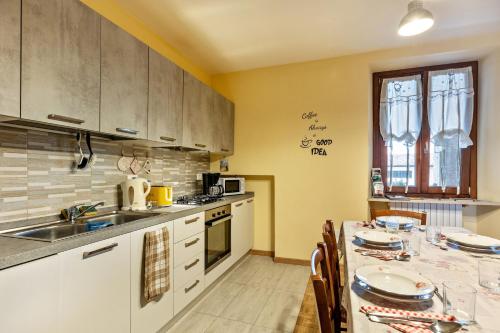 a kitchen with a sink and a table with chairs at Cascina Raperonzolo in Lonato del Garda