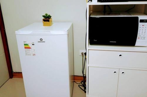 a white refrigerator next to a microwave oven at Hospedaje Libertador San Martín - Dpto. entero # 1 in Víctor Larco Herrera