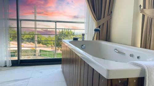 uma casa de banho com banheira e uma grande janela em Villa w Pool Jacuzzi 5 min to Marina in Antalya em Finike