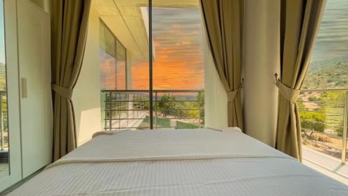 a bed in a room with a large window at Villa w Pool Jacuzzi 5 min to Marina in Antalya in Finike