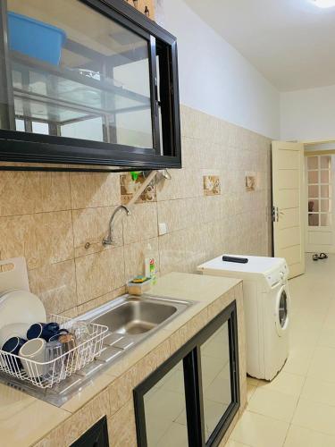 a kitchen with a sink and a washing machine at Appartement xandra in Dakar