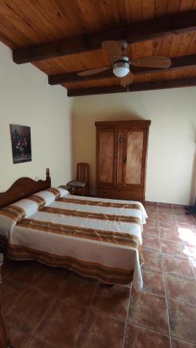 a bedroom with a large bed with a wooden ceiling at Los rosales in Burunchel
