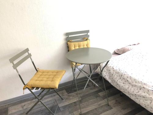 une table et deux chaises à côté d'un lit dans l'établissement Beau studio avec piscine, à Cannes