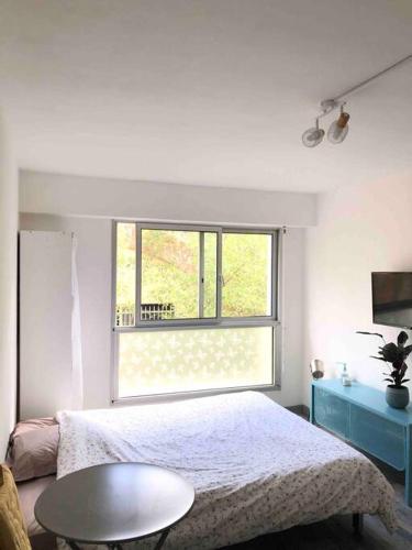 une chambre avec un lit, une table et une fenêtre dans l'établissement Beau studio avec piscine, à Cannes