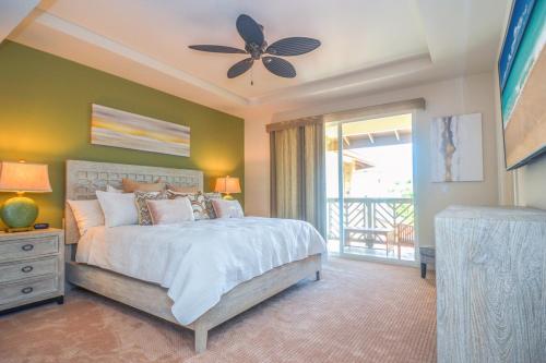 Un dormitorio con una cama y un ventilador de techo. en Pili Mai 8I, en Koloa