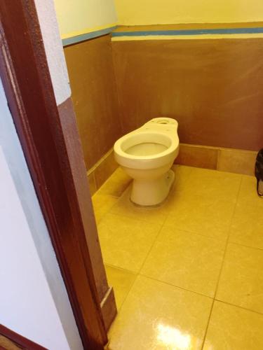 a bathroom with a white toilet in a room at Hostal Qhana Pacha in Isla de la Luna
